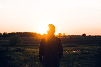 Silhouette of Man Standing in Field at Sunset