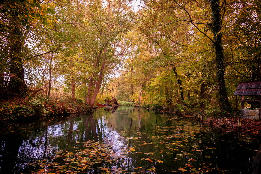 Autumnal River Landscape With Reflections And Small Boat
