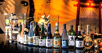 Assorted Japanese Sake Bottles Displayed On A Bar Counter