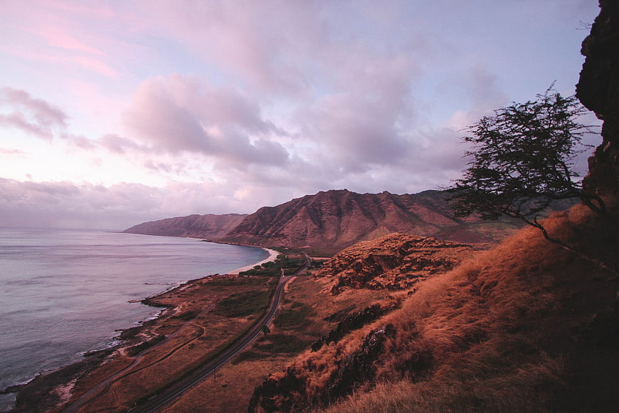 Scenic coastal highway winding along rugged mountains at sunset
