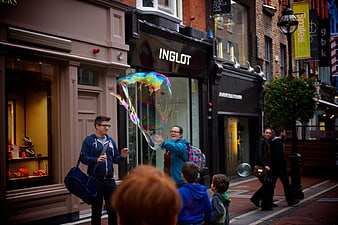 Woman creating giant soap bubble on Dublin street