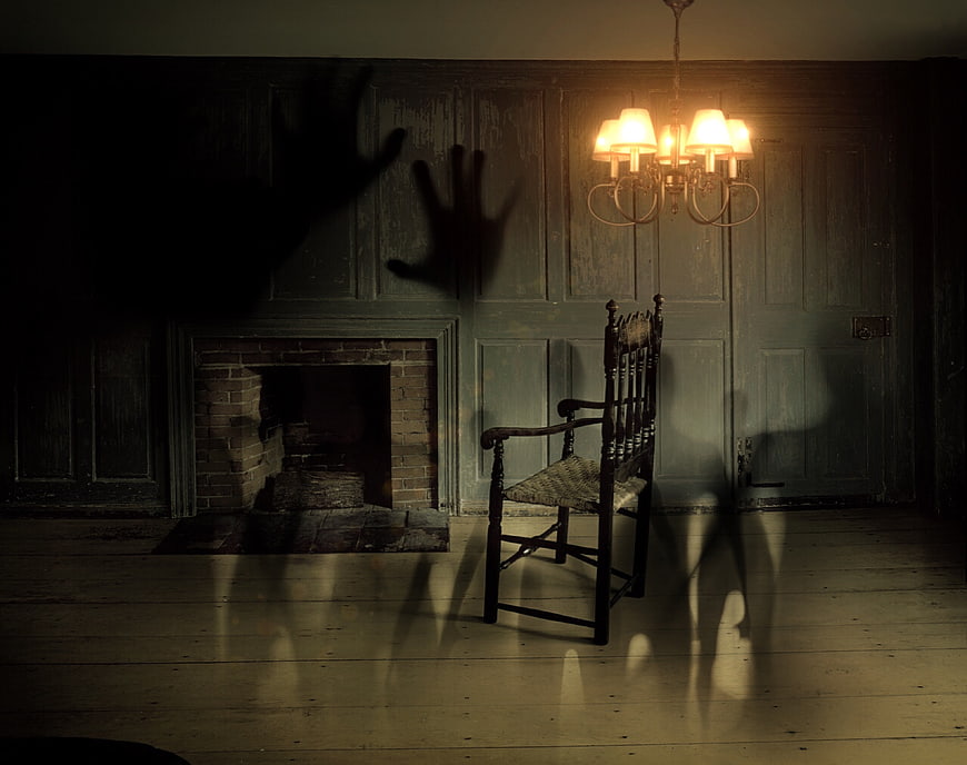 Spooky haunted room with ghostly hand shadows and vintage chair