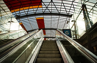 Modern Escalator in Glass Architecture with Red and Yellow Ceiling