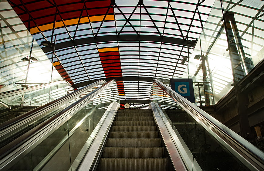 Modern Escalator in Glass Architecture with Red and Yellow Ceiling