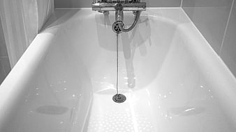 Clean White Bathtub with Chrome Faucet in Black and White