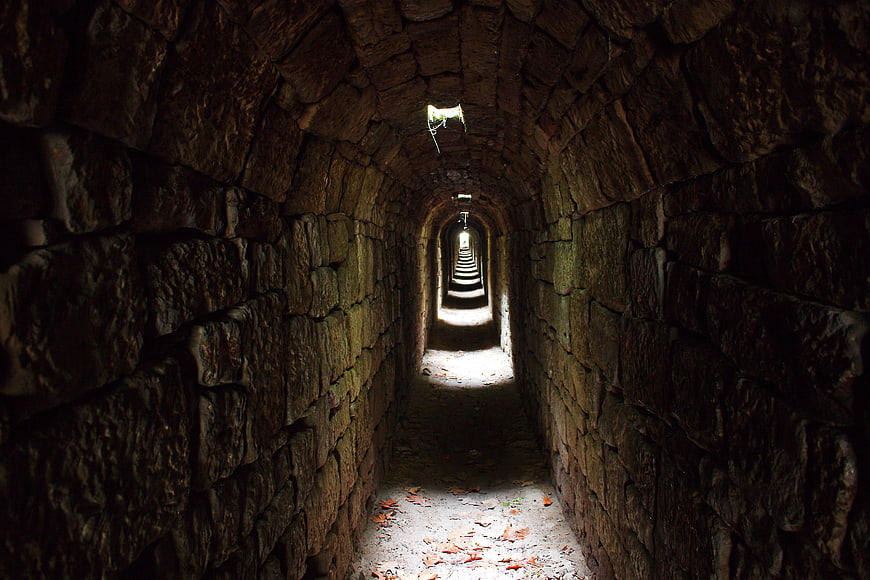 Ancient Stone Tunnel With Arched Passages And Dramatic Light