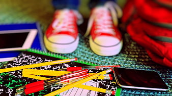 Back to school supplies with red sneakers and smartphone