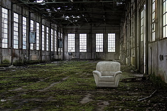 Abandoned Factory Interior with Mossy Floor and White Armchair