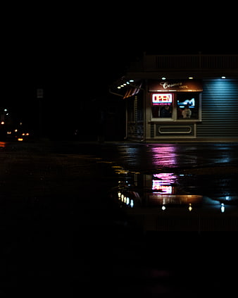 Neon Open Sign Reflection in Rainy Street Puddle at Night