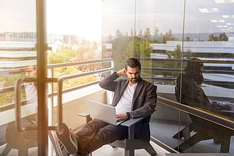 Stressed businessman working on laptop in modern office