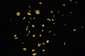 Gold flakes scattered on a black background