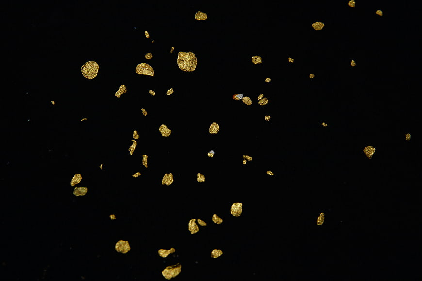 Gold flakes scattered on a black background