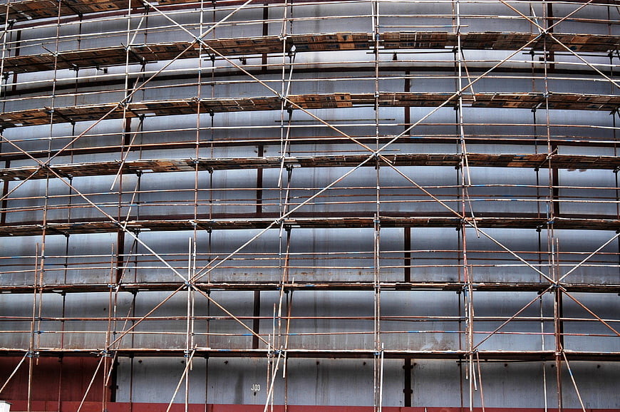 Rusty metal scaffolding structure on industrial building facade