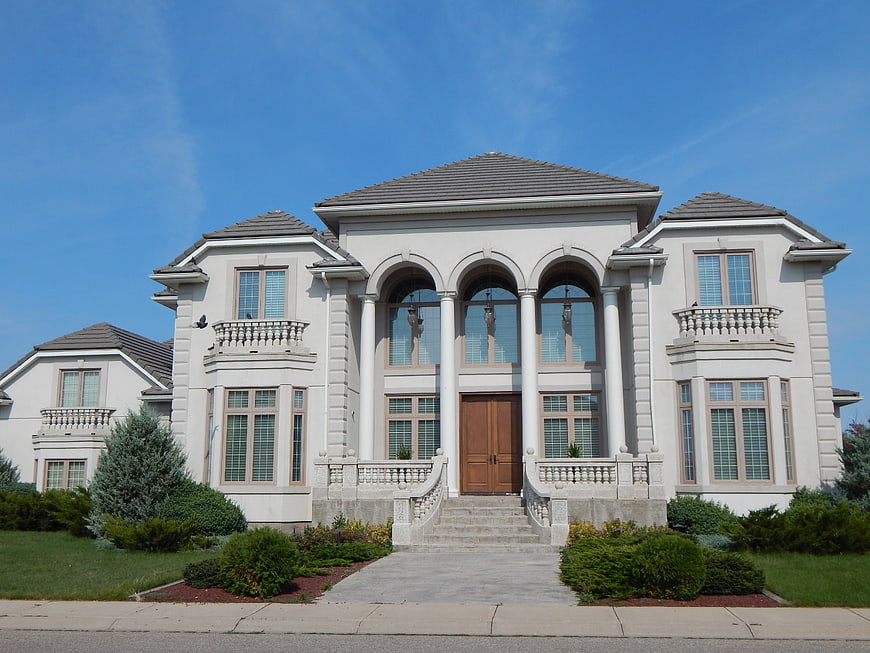 Luxury white mansion with columns and arched windows