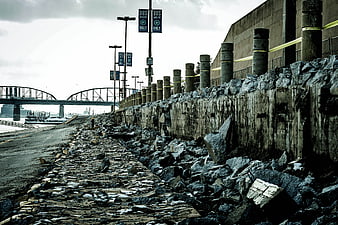 Gloomy Industrial Riverbank With Concrete Wall And Bridge