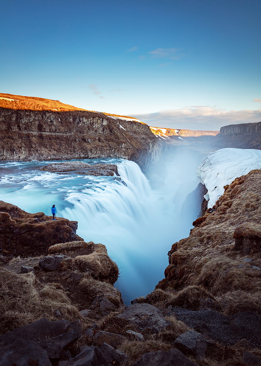 Woman standing near majestic Gullfoss waterfall in Iceland