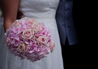 Bride holding pink rose and hydrangea wedding bouquet