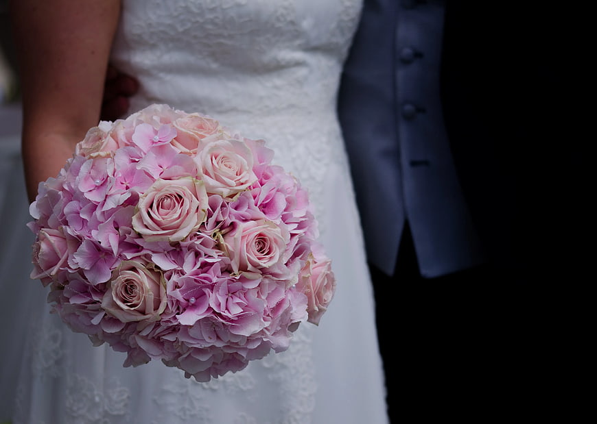 Bride holding pink rose and hydrangea wedding bouquet