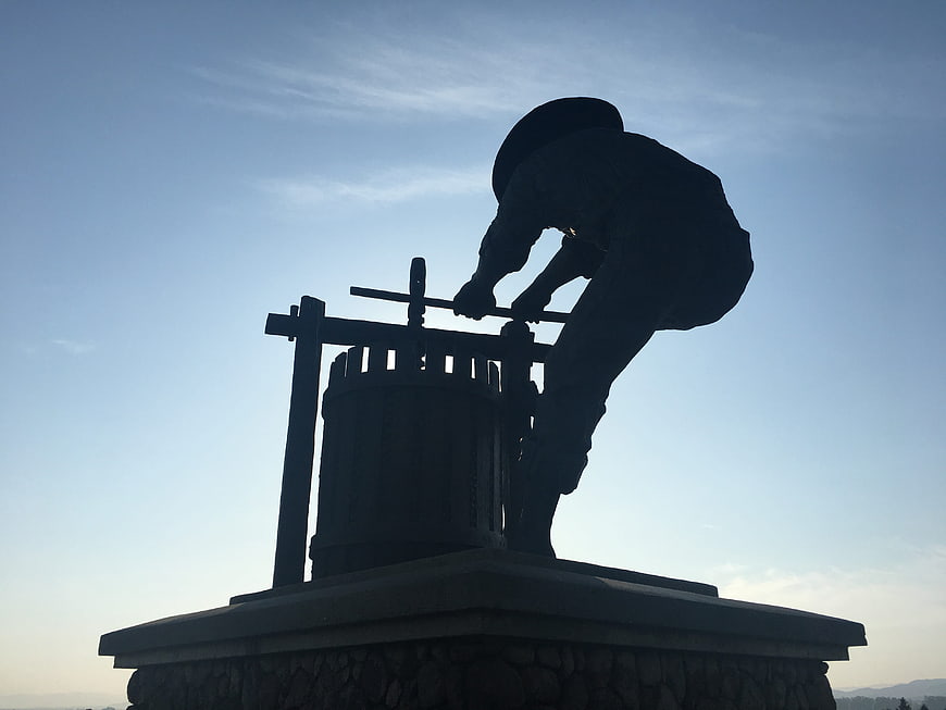 Silhouette of a man drawing water from a well statue