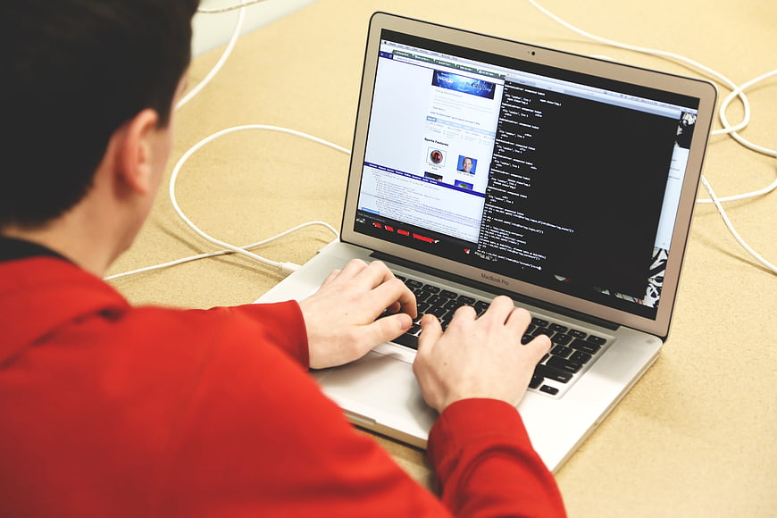 Man coding on laptop with terminal and browser open