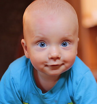 Close-up portrait of a smiling baby boy with blue eyes