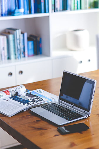 Acer Laptop And Smartphone On Wooden Desk With Open Magazine