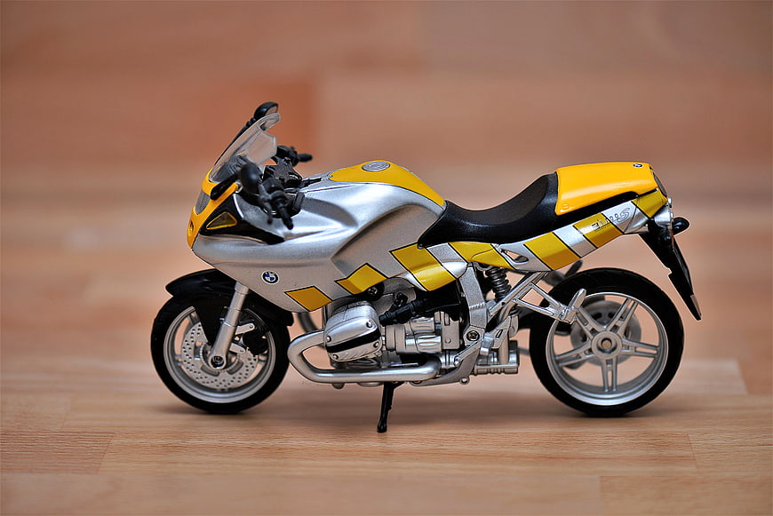Yellow and Silver BMW Motorcycle Model on Wooden Floor