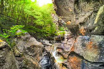 Lush Green Waterfall Cascading Through Rocky Canyon Gorge