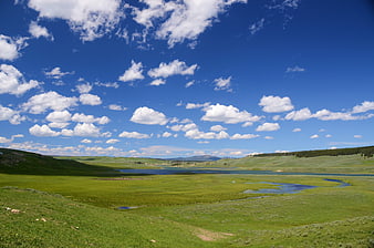 Scenic Green Valley with Lake and Blue Sky