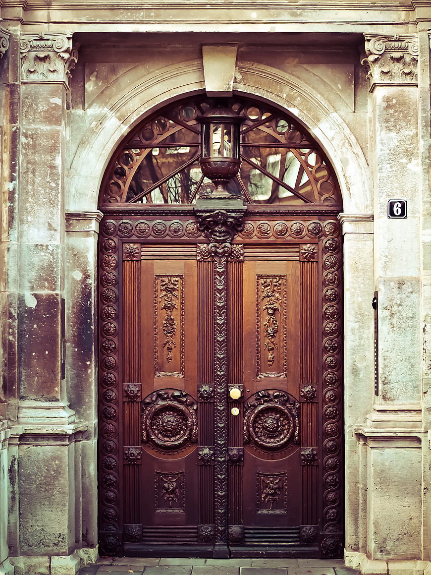 Ornate Brown Wooden Door with Stone Archway