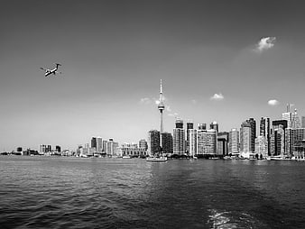 Black and white Toronto skyline with CN Tower and airplane