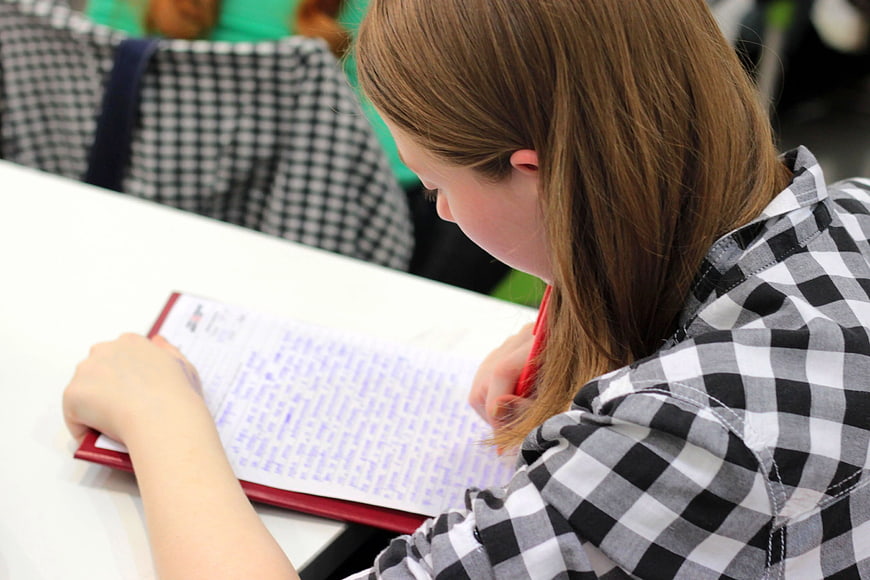 Woman Writing in Notebook at Desk