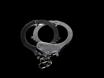 Silver handcuffs with chain on black background