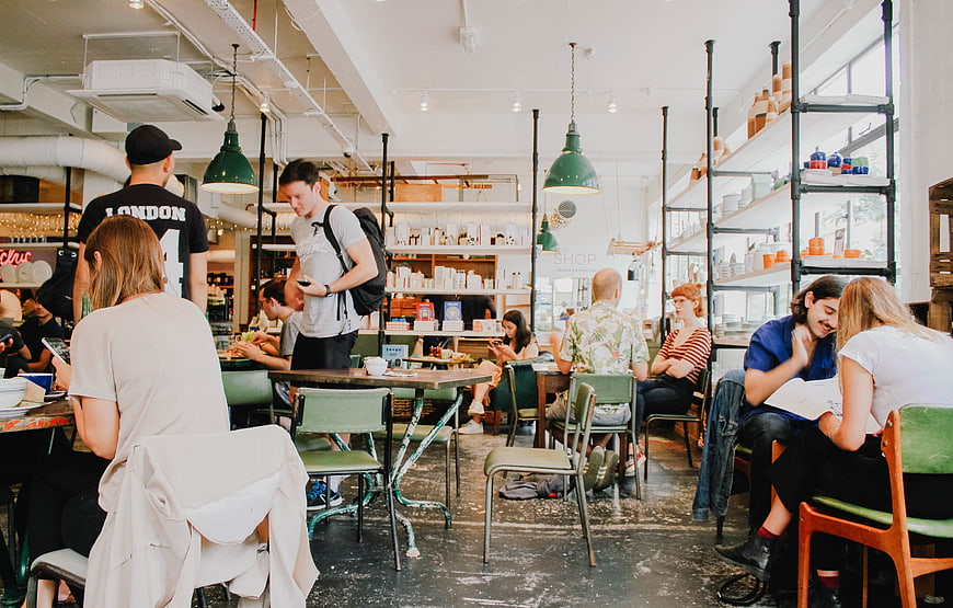 Busy modern cafe interior with customers dining and socializing