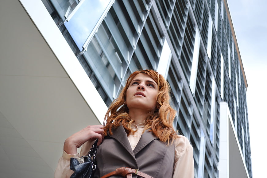 Low angle portrait of young businesswoman in front of modern office building