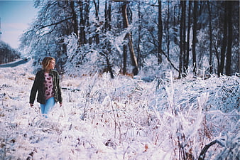Young Woman Walking in Snowy Winter Forest Landscape