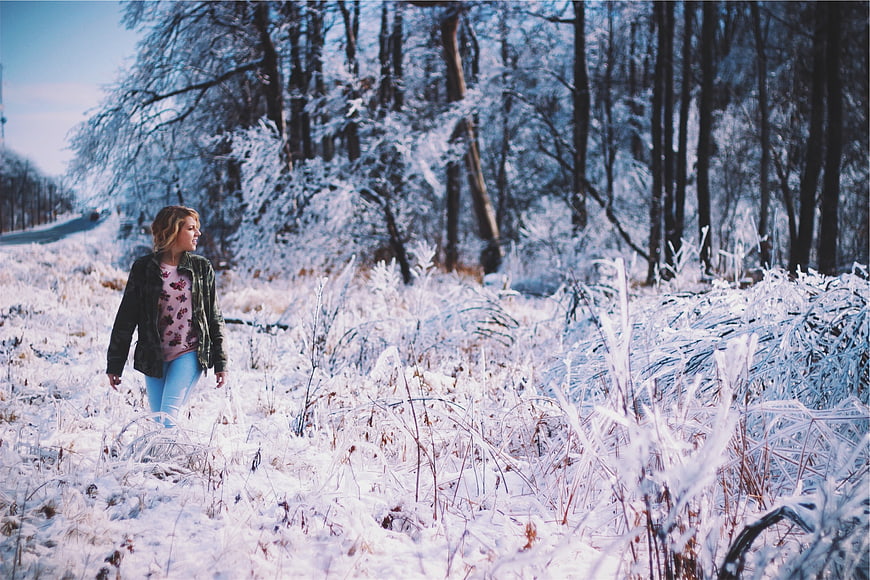 Young Woman Walking in Snowy Winter Forest Landscape
