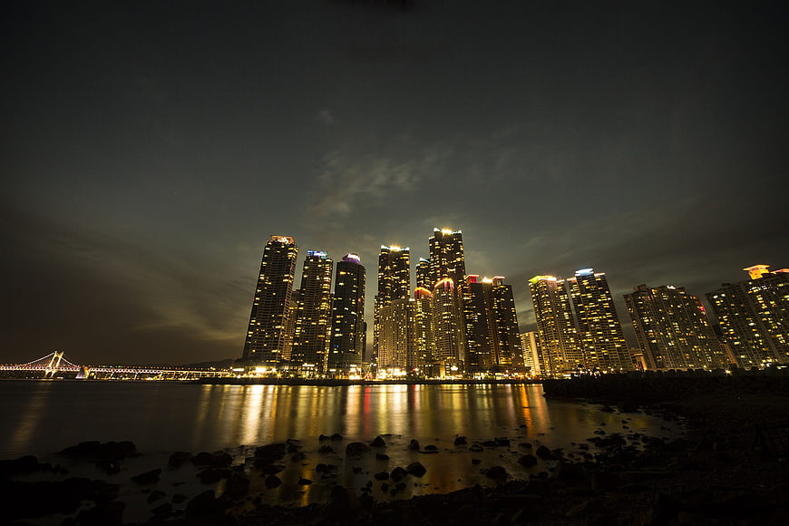 Night Skyline of Busan with Skyscrapers and Bridge Reflection