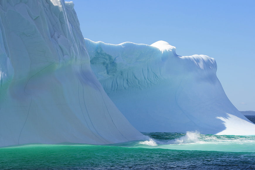 Massive Blue Iceberg Floating in Turquoise Arctic Ocean