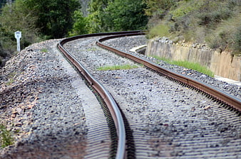 Curved Train Tracks Winding Through Green Forest Landscape