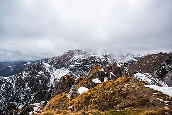Snowy Mountain Peaks with Cloudy Sky and Rocky Ridge