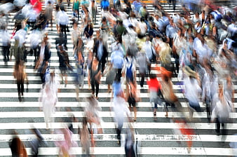 Motion blur crowd crossing busy city street in Japan