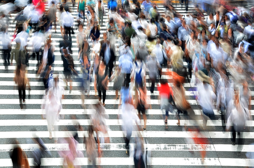 Motion blur crowd crossing busy city street in Japan