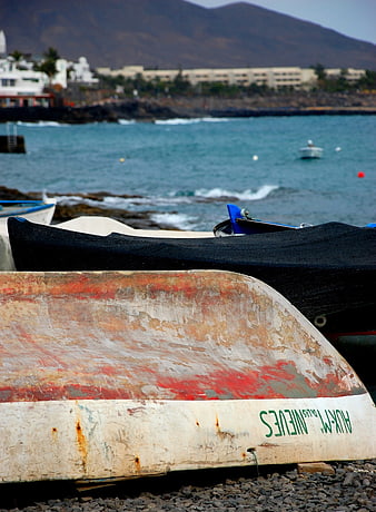 Weathered Fishing Boat on Rocky Beach with Ocean View
