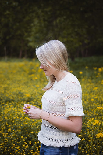Blonde Woman in White Crochet Top Standing in Yellow Flower Field