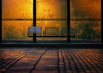 Empty metal bench at urban bus stop with golden light