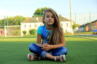 Young Girl Sitting on Artificial Turf Sports Field