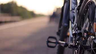 Close-up of bicycle wheel and brake on a blurred road
