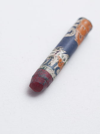 Worn red crayon on white background