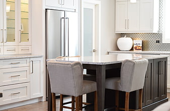 Modern kitchen island with gray bar stools and white cabinetry